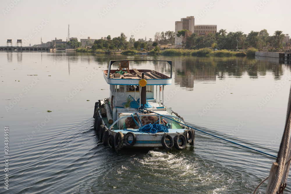 Tug boat towing yacht on nile river in Egypt Tug boat towing yacht on nile river in Egypt