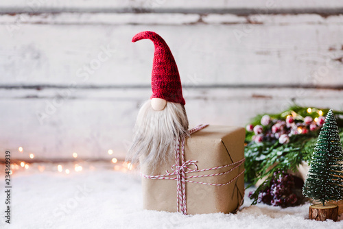 Bald ist Weihnachten! Kleiner Wichtel sitz auf Geschenk  vor weihnachtlich, winterlicher Dekoration photo