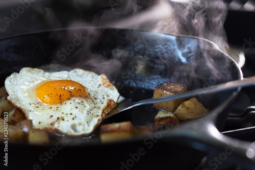 Eggs and potatoes cooking on a pan