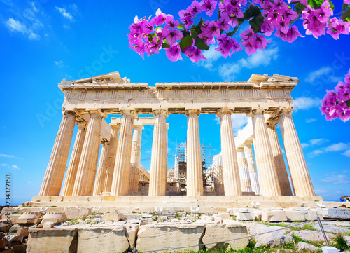 facade of Parthenon temple over bright blue sky background with flowers, Acropolis hill, Athens Greece