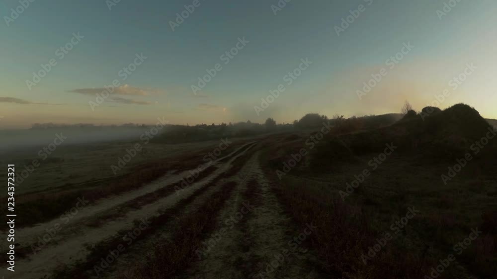 Road in the morning mist behind the village Road in the morning mist behind the village