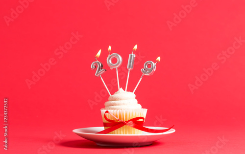 2019 new year celebration theme with cupcake and candles