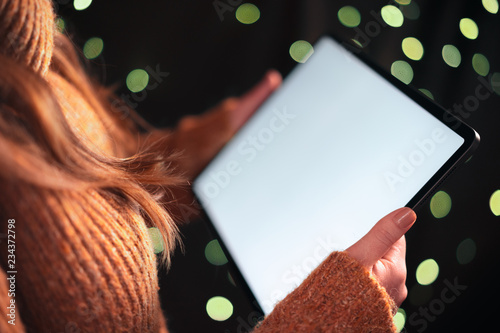 Papier peint Woman using tablet computer at night with dramatic lighting and shallow depth of field