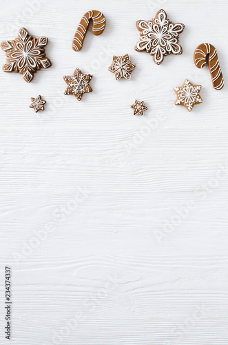 Christmas homemade gingerbread cookies on the white wooden background.
