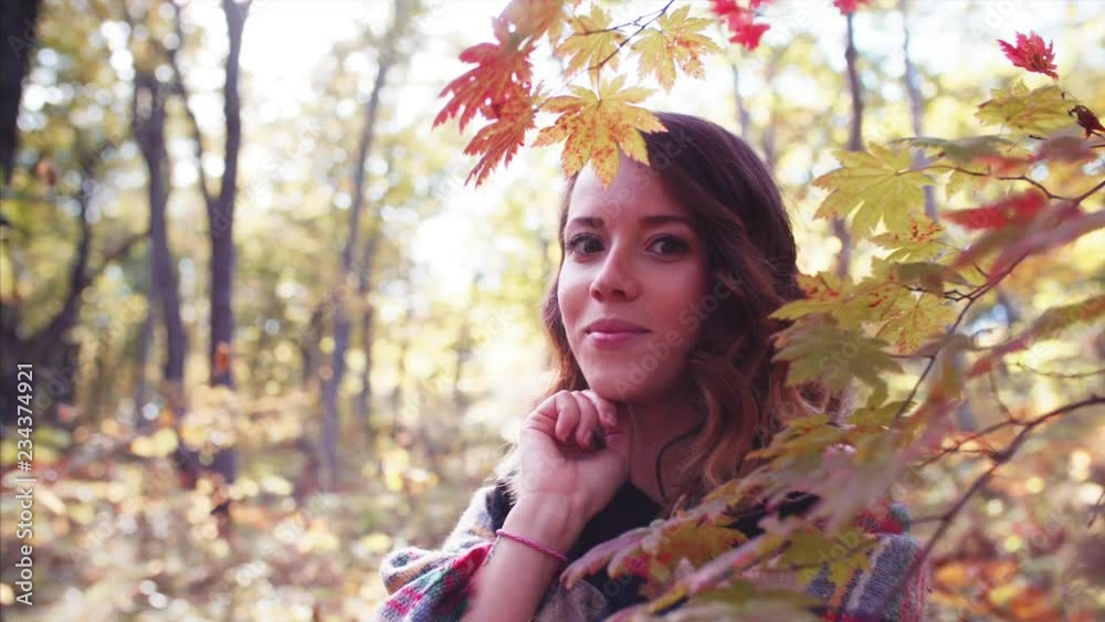 Sliding portrait of brunette woman looking into the camera in autumn forest. Sliding portrait of brunette woman looking into the camera in autumn forest.