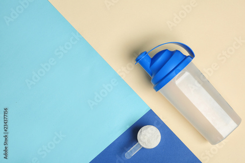 Flat lay composition with protein powder, bottle and space for text on color background. Preparing shake