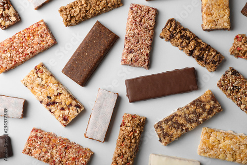 Flat lay composition with protein bars on grey background