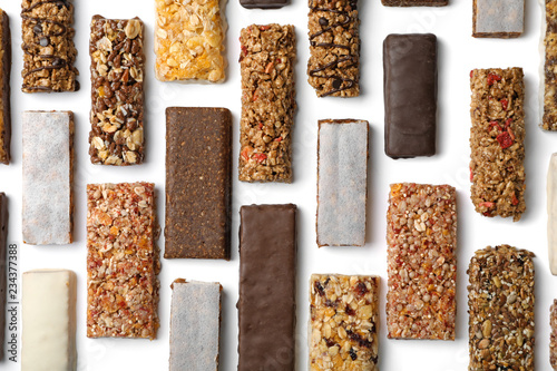 Flat lay composition with protein bars on white background