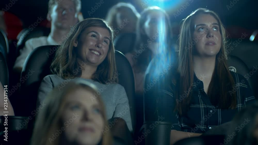 Happy, smiling and laughing movie theatre crowd enjoying a comedy film