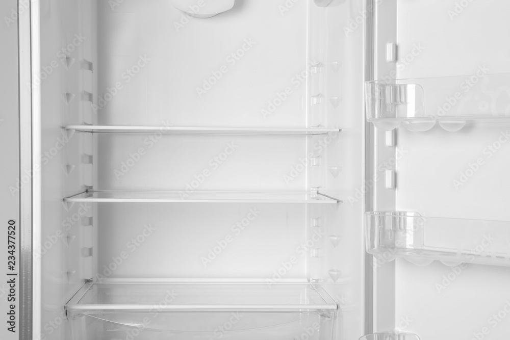 Modern open refrigerator with empty shelves, closeup Modern open refrigerator with empty shelves, closeup