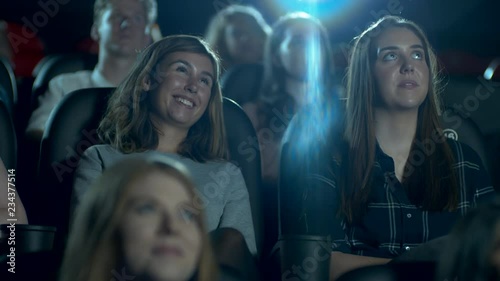 Happy, smiling and laughing movie theatre crowd enjoying a comedy film