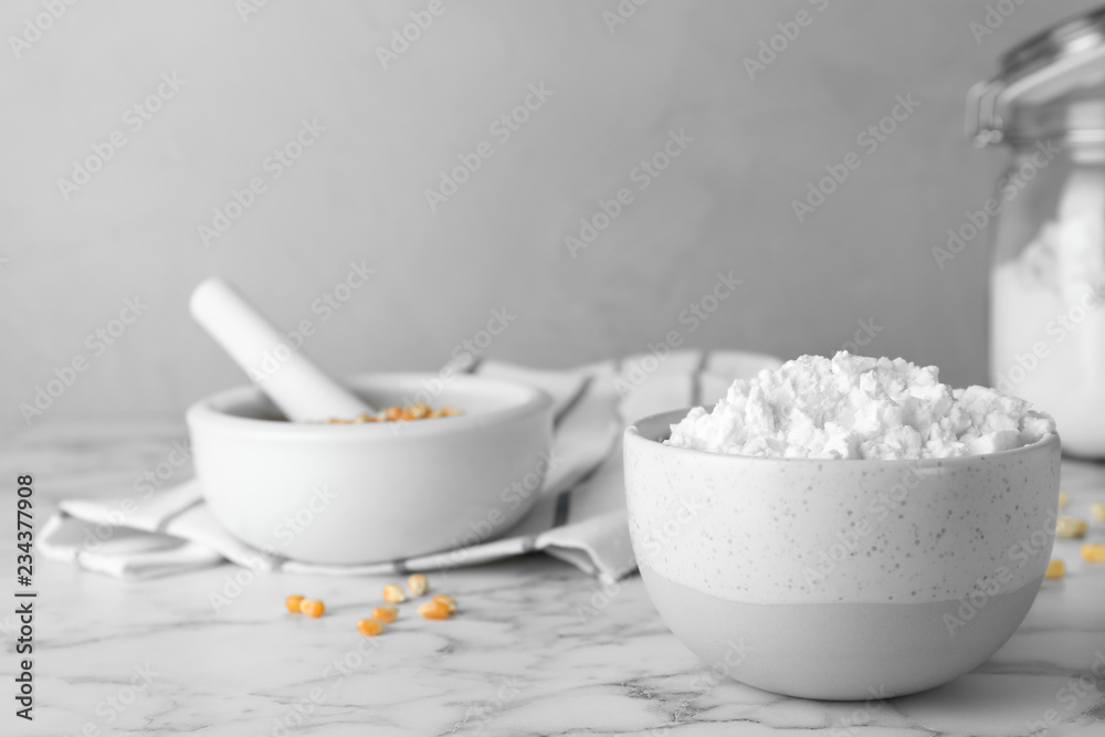 Bowl with corn starch on marble table. Space for text Bowl with corn starch on marble table. Space for text