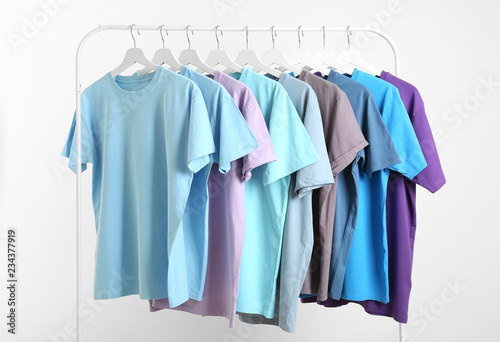 Men's clothes hanging on wardrobe rack against white background © New Africa