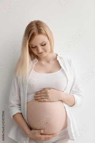 Free Download Portrait of beautiful pregnant woman on light background - GFXLoad