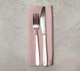 Fork, knife and linen napkin on grey background, top view