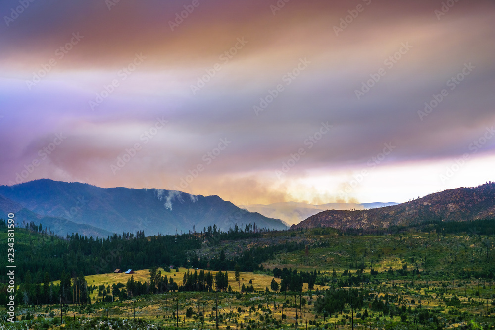 View towards Ferguson Fire burning just outside Yosemite National Park; colorful smoke clouds covering the sun; California