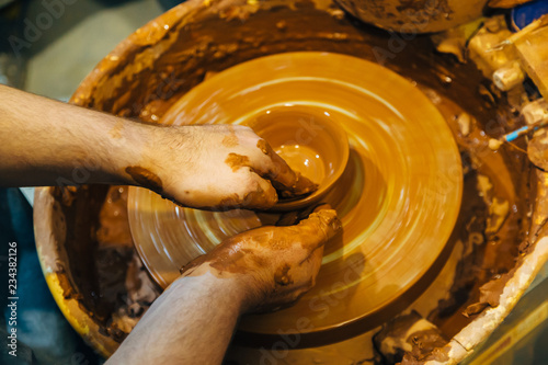 Potter works with clay on potter's wheel