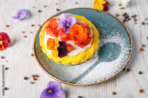 Strawberry tart garnished with edible flowers