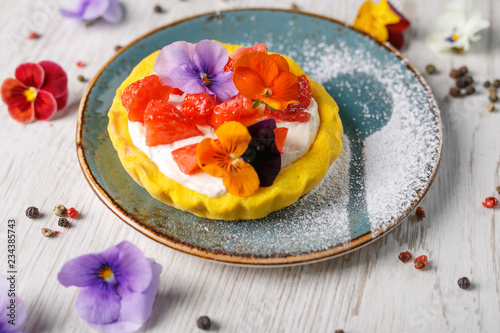 Strawberry tart garnished with edible flowers