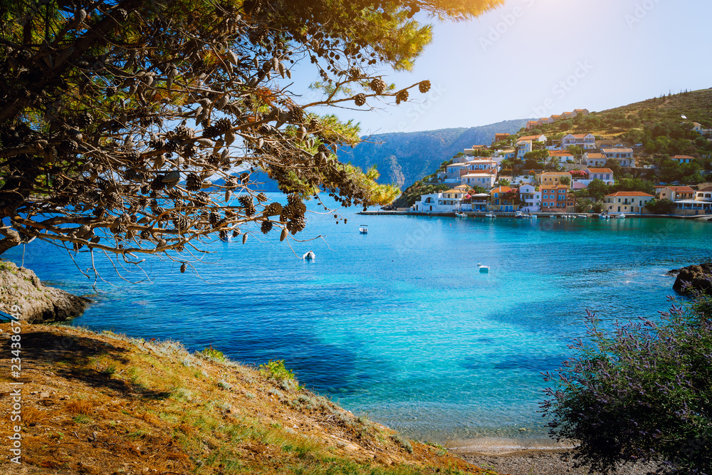 Beautiful blue bay surrounded by pine trees in Assos village located on Kefalonia. Summer tourism vacation trip around Greece