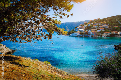 Beautiful blue bay surrounded by pine trees in Assos village located on Kefalonia. Summer tourism vacation trip around Greece photo