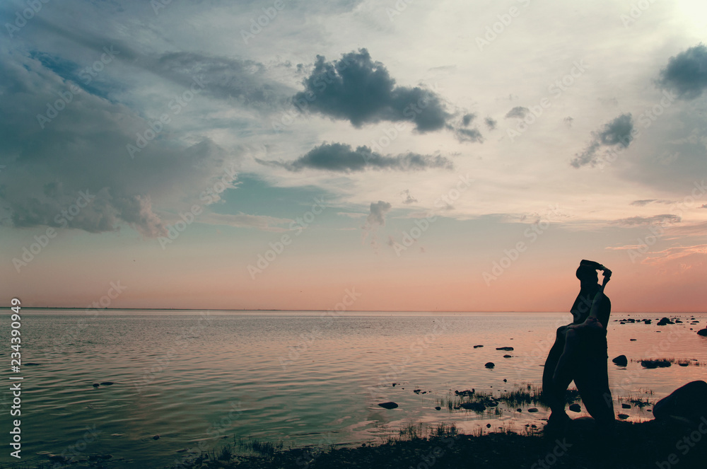 couple at dusk on the beach watching the sunset over the water