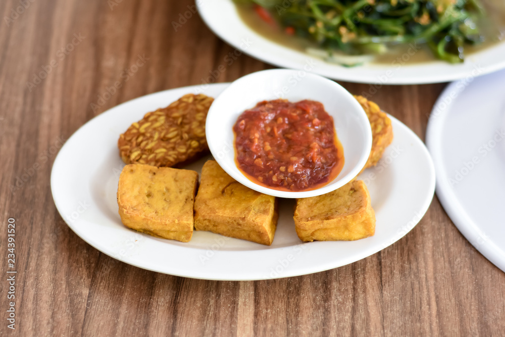 Baceman. Fried food dish of sweet-soy braised bean curd, tempeh, and offal. Popular side dishes in Javanese meals. Served on woven bamboo plate. Baceman. Fried food dish of sweet-soy braised bean curd, tempeh, and offal. Popular side dishes in Javanese meals. Served on woven bamboo plate.
