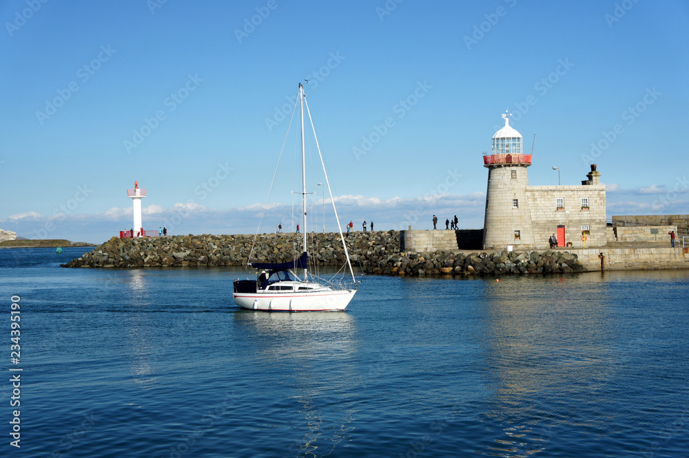 Calm sea.Lighthouse at the entrance to the port of Howth.Ireland.