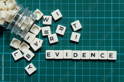 Evidence word made of square letter word on green square mat background.
