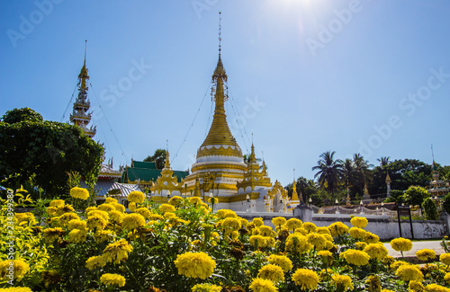 Wat Chong Klang,Mae Hong Son,northern Thailand on November 19,2017:Burmese-style white and golden chedi and 5-tier pyatthat with blue sky background photo