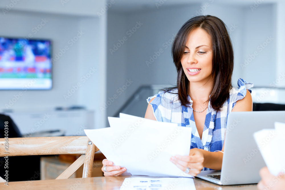 Woman with papers in their living room Woman with papers in their living room