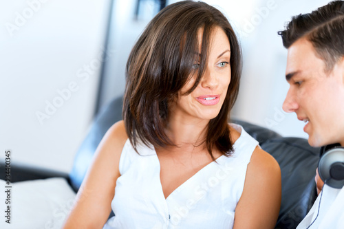 Young couple looking at something while sitting at home