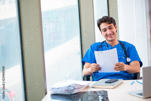 Tableau sur toile Young handsome doctor working in the hospital