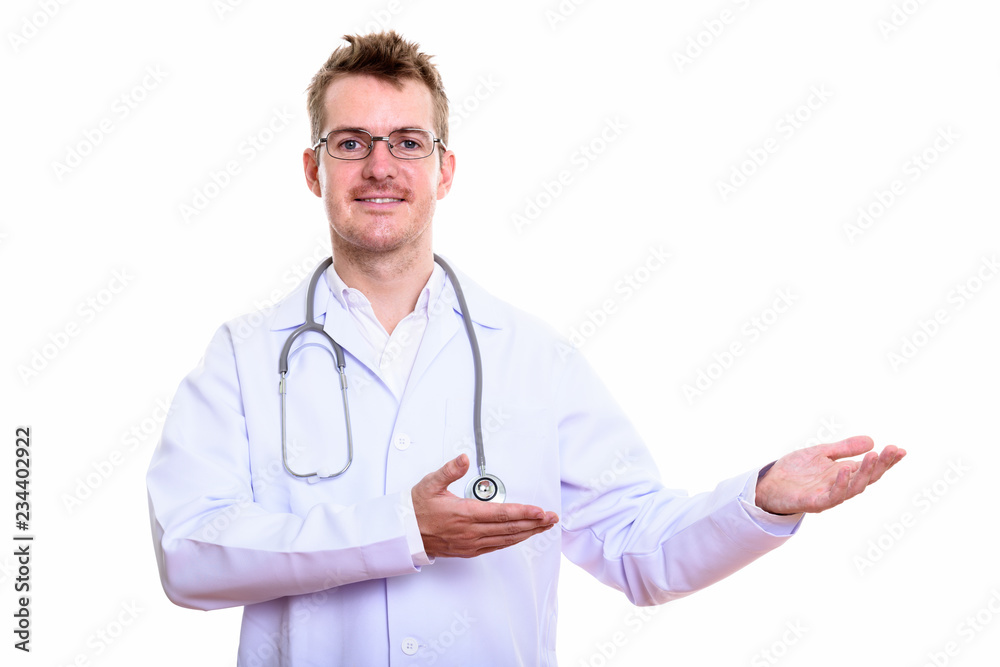 Studio shot of happy man doctor smiling while showing something Studio shot of happy man doctor smiling while showing something