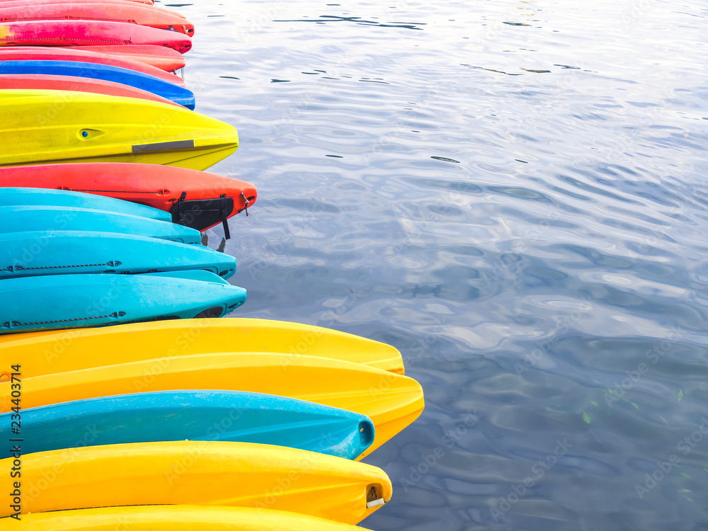 Row of colorful fiberglass kayaks in the sea Row of colorful fiberglass kayaks in the sea