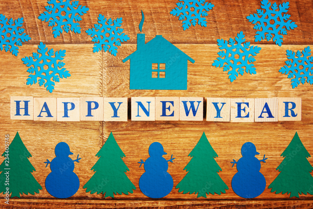 Text Happy New Year on wooden background with festive bright colorful paper figures