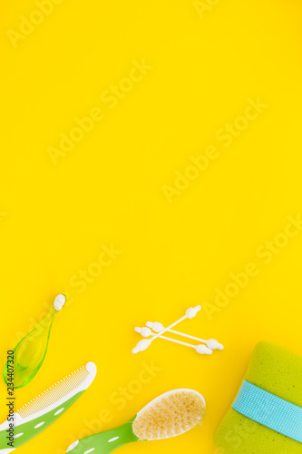 Children's personal care kit. Bath accessories with teeth brush on yellow background top view space for text