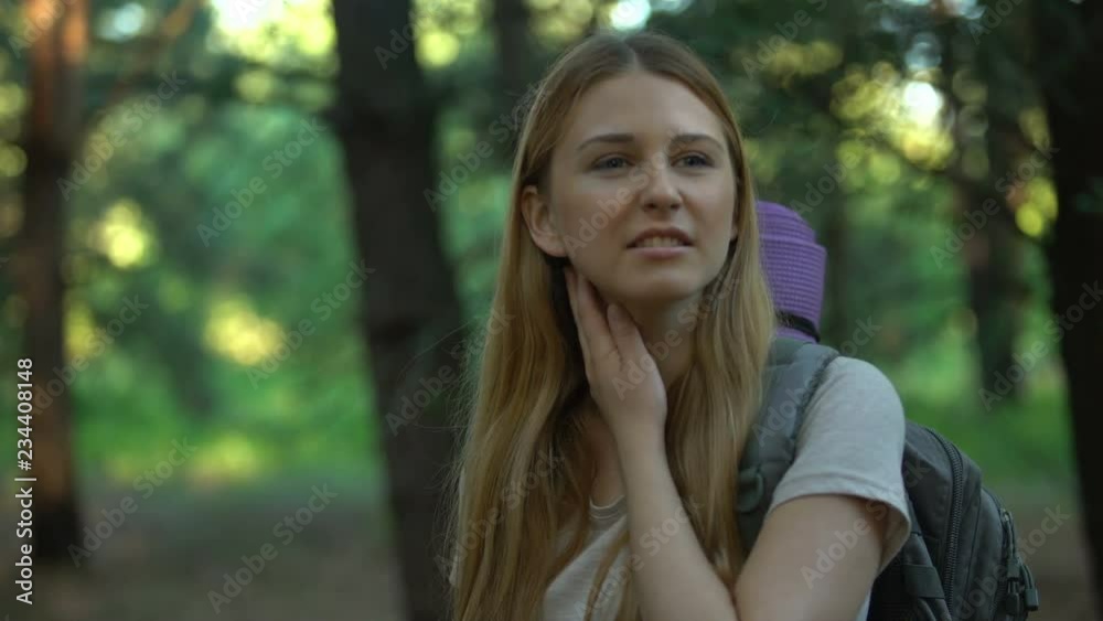 Lady suffers from mosquitoes bite while camping, killing bug with hand, itching Lady suffers from mosquitoes bite while camping, killing bug with hand, itching