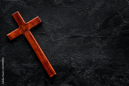 Funeral concept. Wooden cross on black background top view copy space