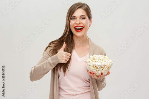 Smiling woman holding popcorn show thumb up.