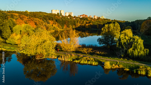 Fototapeta Naklejka Na Ścianę i Meble -  Golden autumn background, aerial drone view of forest with yellow trees and beautiful lake landscape from above, Kiev, Goloseevo forest, Ukraine
