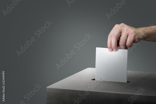 Hand holding ballot paper for election vote at place election background. Election vote concept. photo