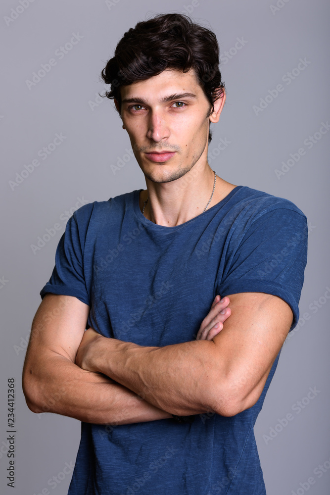 Studio shot of young handsome man with arms crossed Studio shot of young handsome man with arms crossed