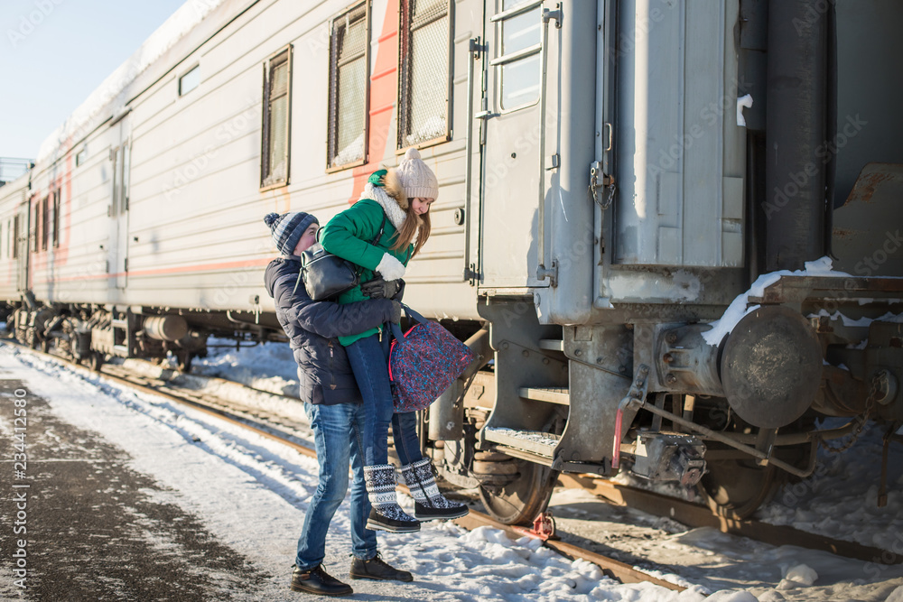Couple at railway station near train in a winter time Couple at railway station near train in a winter time