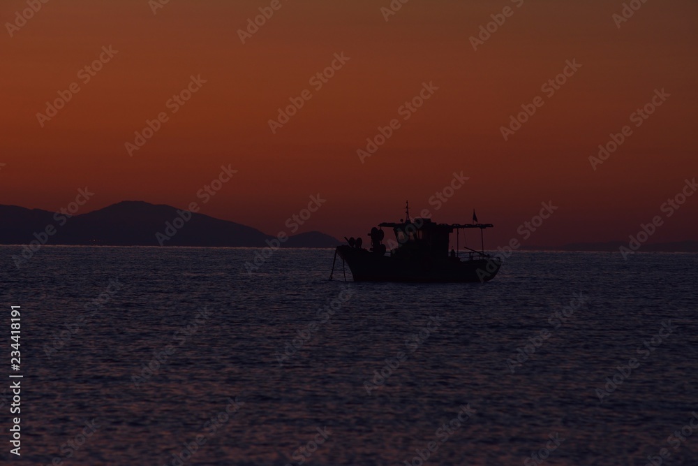 boat sunset in corfu island, greece