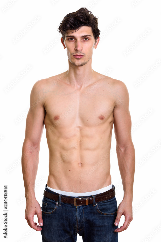 Studio shot of young handsome man standing shirtless