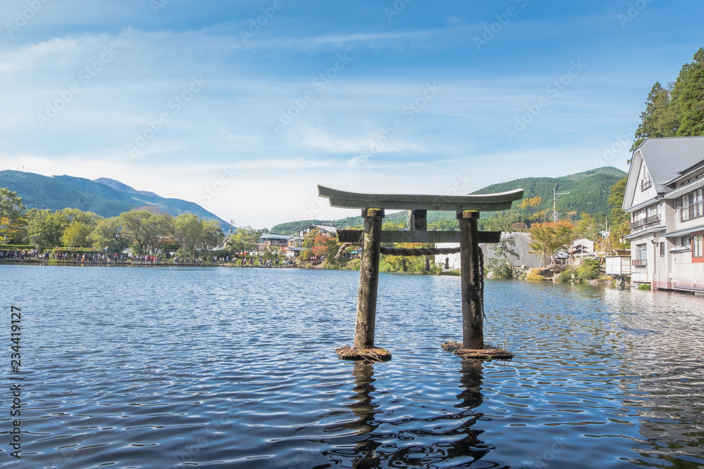 Lake Kinrin and Japanese gate (Torii) with Mount Yufu and blue sky background at Yufuin, Oita, Kyushu, Japan