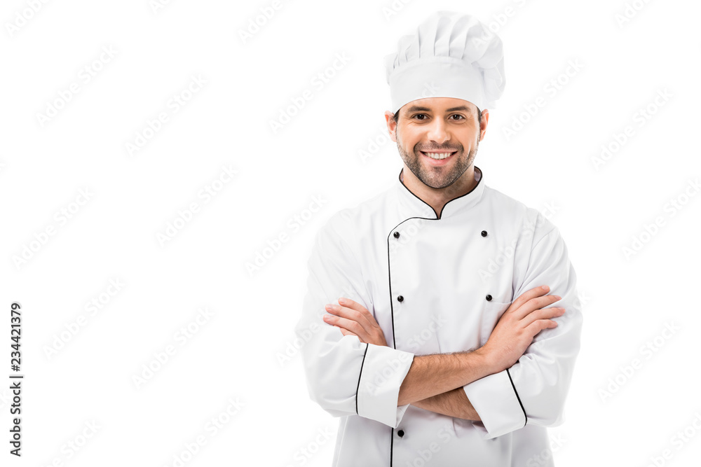 smiling young chef with crossed arms looking at camera isolated on white