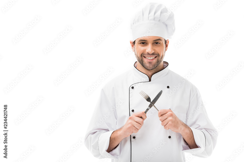 smiling young chef holding fork and knife and looking at camera isolated on white smiling young chef holding fork and knife and looking at camera isolated on white
