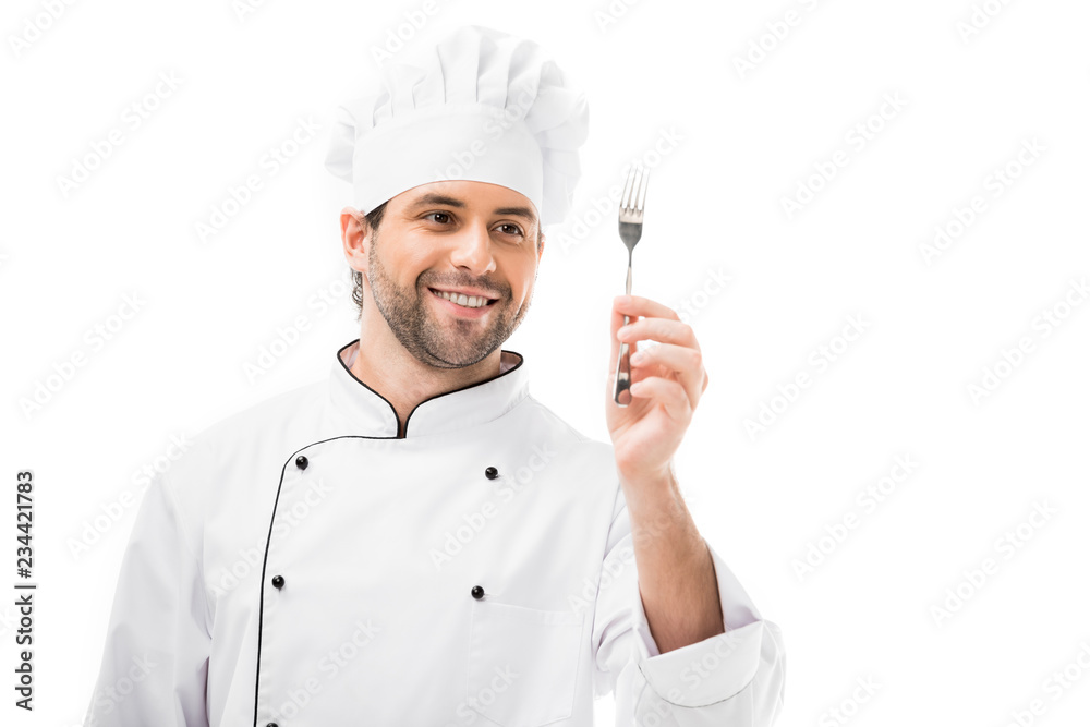 happy young chef holding fork isolated on white happy young chef holding fork isolated on white